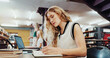 © peopleimages.com - Woman, student and writing with book in library for studying, education or learning in school. Female person, university or taking notes with diary or notebook for project research or assessment