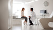 © Vasyl - Doctor consulting with a female patient in a modern, bright examination room. A male physician in a white coat discusses medical information with a woman seated on an examination table