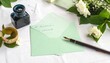 © 恵美 國重 - 白いテーブルクロスの上に書きかけの手紙とペンが置かれている。途中まで書かれた文章が静かな時間と物語を感じさせる。シンプルな白い背景が手紙とペンを引き立てる構図。