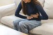 © Pormezz - young woman gripping her stomach have abdominal pain .