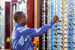 © Roger - Senior African customer selecting frames on display in an optometrist shop for better vision