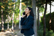 © Parichat - Happy Asian woman talking phone managing business outdoors