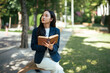 © Parichat - Young Asian woman reading book outdoors searching inspiration