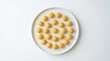 © AridhoNurrizta - Delightful golden round pastries artfully arranged in a decorative circle on a pristine white background, highlighting their uniform shape and appealing texture for a charming treat