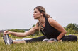 © peopleimages.com - Fitness, stretching or woman with earphones on grass, outdoor exercise or streaming music for warm up. Muscle mobility, nature or runner with tech for workout preparation, radio or listen to podcast
