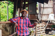 © arrowsmith2 - Proud African Farmer Holding Farming Tool in Traditional Cattle Shed