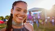 © ImageThink - Happy young woman smile close up at vibrant music festival with crowd and stage in background