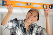 © auremar - smiling female worker using a spirit level