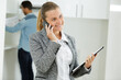 © auremar - businesswoman talking on cell phone and holding a clipboard