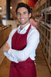 © auremar - smiling male seller in uniform posing in wine store