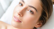 © Celt Studio - Beautiful young woman face close up portrait perfect clean glowing skin resting white pillow spa wellness cosmetics beauty skincare concept