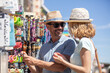© auremar - tourist couple shopping for souvenirs in a vacations destination