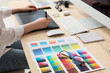 © Pixel-Shot - Female designer working with graphic tablet and color palettes at table in office, closeup