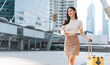 © dodotone - Beautiful confidence smile Freelance young adult asian woman walking with travel luggage for business trip