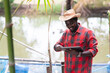 © arrowsmith2 - African Smart Farmer Using Tablet at Fish Farm Pond