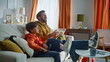 © stockbusters - Father son watching television relaxing cozy sofa together. Smiling man boy