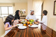 © oneinchpunch - Arab family wearing traditional emirati clothing bonding at home in Dubai