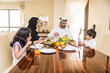 © oneinchpunch - Arab family wearing traditional emirati clothing bonding at home in Dubai