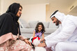 © oneinchpunch - Arab family wearing traditional emirati clothing bonding at home in Dubai