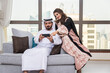 © oneinchpunch - Arab married couple wearing traditional emirati clothing at home - Middle eastern man and woman spending time together, domestic life in a traditional middle east family