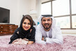 © oneinchpunch - Arab married couple wearing traditional emirati clothing at home - Middle eastern man and woman spending time together, domestic life in a traditional middle east family