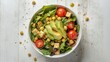 © VolumeThings - Healthy salad bowl with chick pea, tomatoes, tofu, avocado, greens on light background top view