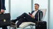 © twilight mist - Mature businessman relaxes in modern airport lounge while holding travel documents and mobile device