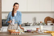 © Pixel-Shot - Young woman with mixer cooking at table in kitchen