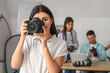 © Pixel-Shot - Female photographer with camera during courses in studio