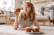 © Pixel-Shot - Young woman with tasty muffins lying on floor at home