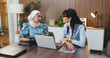 © peopleimages.com - Woman, laptop and documents with team in office meeting for strategy, admin or insight at insurance company. Person, broker and listen with tech on application, feedback or risk management at agency