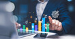 © Aytana - Investing for financial growth: businessman using laptop with virtual chart to analyze income and wages increase, economic improvement, and investment portfolio profitability.