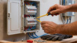 © Jakub - The electrician is working, The panel is open, He checks the wires, Tools are in use, It is electrical work, Maintenance is being done, The power is off, It is a professional job