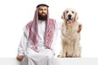 © Ljupco Smokovski - Saudi arab man sitting on a blank panel nd hugging a retriever dog