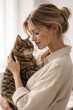 © Rawpixel.com - Woman affectionately holding tabby cat.