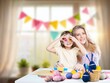 © BillionPhotos.com - Happy mother and daughter painting easter eggs.