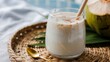 © AnowarHossen - Creamy blended drink with cinnamon dust, gold spoon, and whole coconut