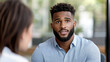 © syhin_stas - Young black man engaging in a job interview, actively listening to interviewer questions while seeking new employment opportunities and professional career growth