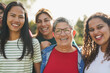 © Sabrina - Happy multiracial women smiling on camera outdoor - Multi generational people having fun hugging each other at park - Diversity, female community and friendship concept