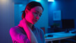 © photo for everything - Woman Experience Neck Pain from Prolonged Business Work, Feeling Discomfort and Stress in a Modern Office Environment at Night with Neon Lights