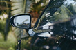 © SHOTPRIME STUDIO - car side mirror black car palm trees reflection tropical closeup outdoor: glossy modern black luxury coupe mirror detail with palm reflections, sunlit bokeh, travel lifestyle vibe on roadside