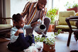 © Marko Geber - Father helping daughter water plants on balcony