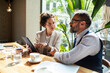 © Marko Geber - Business colleagues discussing strategy with tablet at cafe
