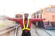 © arrowsmith2 - Successful African Railway Engineer Celebrating Progress at Train Station