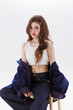 © Auttapol - Young Asian Fashion Woman Sitting on Stool in Casual Denim Outfit Beauty Portrait on Clean Studio Background.