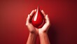 © Clinton - hands holding red blood drop on red background blood donation