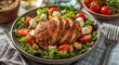© The 2R Artificiality - Crispy chicken breast salad with cheese cherry tomatoes lettuce and herb flavored croutons served on casual table