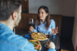 © Dragana Gordic - Couple Enjoying Pizza and Red Wine During a Cozy Restaurant Dinner Date Conversation