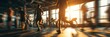 © Agung - Blurred motion of people running on treadmills in a gym with bright sunlight streaming through windows.
