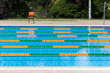 © Austockphoto - Colourful lane ropes set up in a public swimming pool and chair waiting for a swim competition